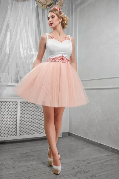 Jovem mulher bonita, bonita em rosa claro vestido curto com vermelho — Fotografia de Stock