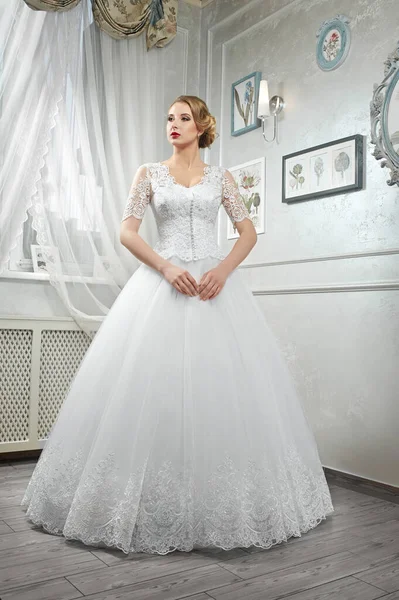 Молода красива наречена, жінка в довгій білій весільній сукні на білому — стокове фото