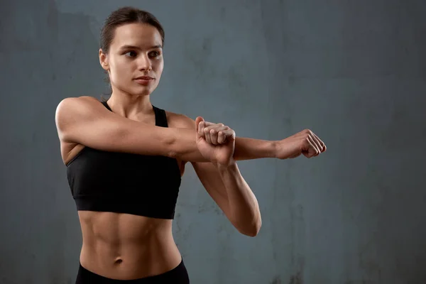 Flexible Fitnessfrau streckt den Arm vor dem Training. — Stockfoto