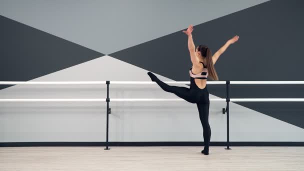 Frau streckt Beine über Geländer im Tanzstudio. — Stockvideo