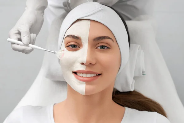 Beautician applying special white mask on face for woman. — Stock Photo, Image