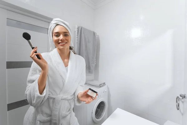 Joven bonita mujer haciendo maquillaje facial en casa. —  Fotos de Stock