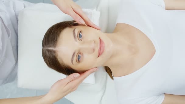 Mujer joven disfrutando de un suave masaje después de limpiar la cara. — Vídeos de Stock