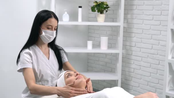 Masseuse esthéticienne en faisant massage du visage pour le client. — Video