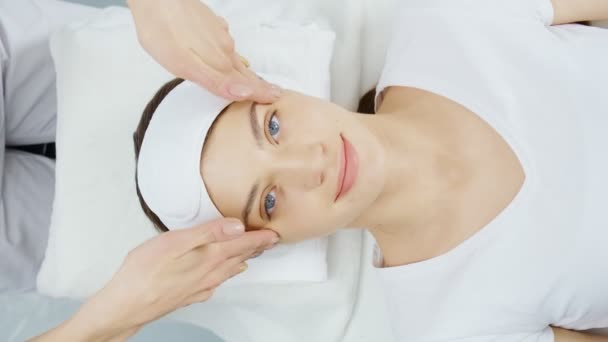 Massagista fazendo massagem facial para jovem mulher bonito. — Vídeo de Stock