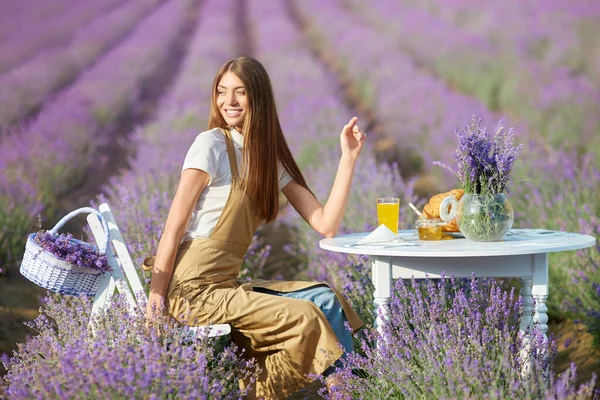 Wanita muda menikmati makan malam di lavender field. — Stok Foto