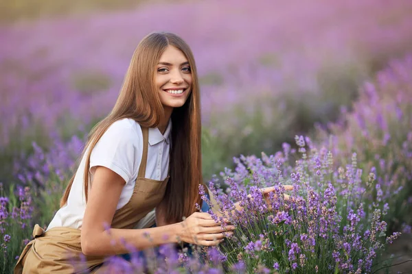 Hymyilevä nainen poseeraa laventelipellolla. — kuvapankkivalokuva