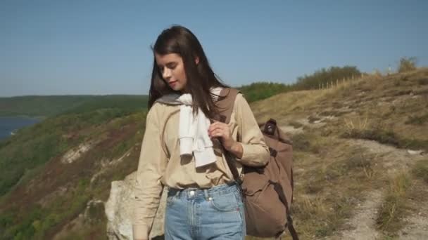 Friedliche Frau läuft mit Rucksack auf hohem Hügel — Stockvideo