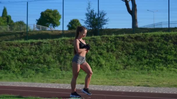 Meisje oefenen lunges tijdens het lopen in het stadion. — Stockvideo