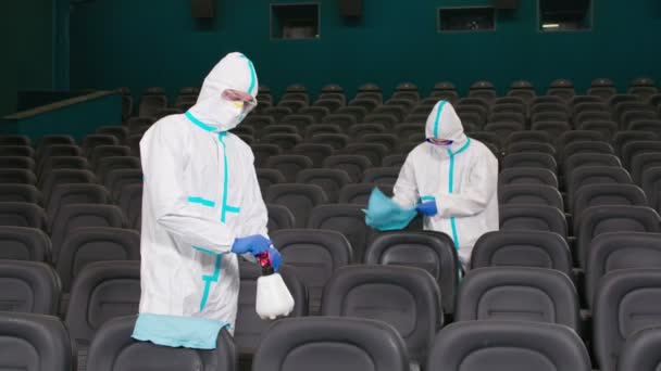 Due operai che puliscono sedie con disinfettanti nel cinema. — Video Stock