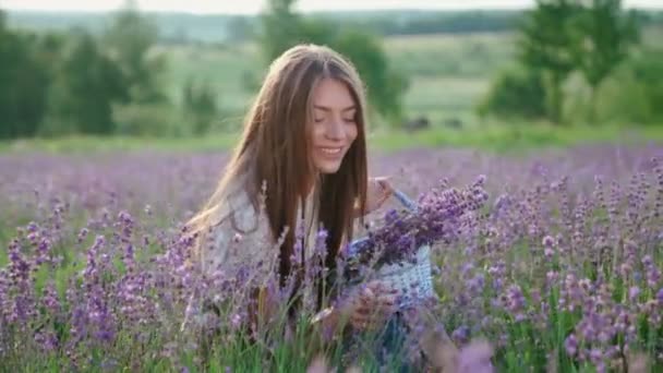 Menina fazenda feliz com cesta de flores, campo de lavanda. — Vídeo de Stock