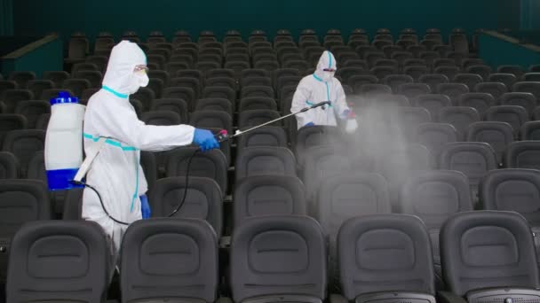 Men using equipment for spraying antiseptic at cinema — Stock Video