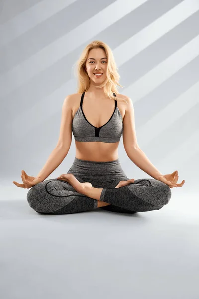 Lächelnde blonde Frau praktiziert Yoga und Meditation. — Stockfoto