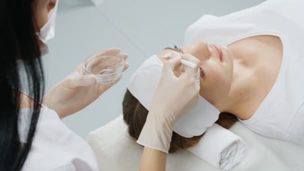 Kosmetolog gör förfaranden fuktgivande ansikte för kvinna. — Stockvideo