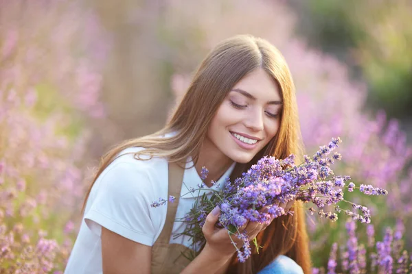 Kaunis nainen haju kukkakimppu tuoksu laventeli alalla. — kuvapankkivalokuva