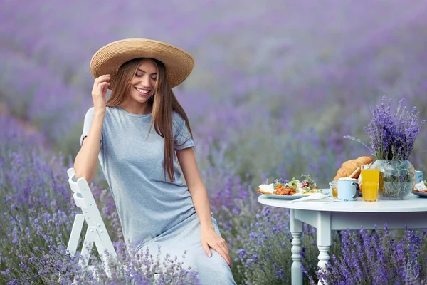 Hymyilevä onnellinen nainen poseeraa laventelipellolla. — kuvapankkivalokuva