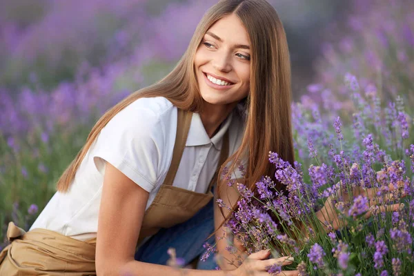 Onnellinen nuori naismaanviljelijä poseeraa laventelipellolla. — kuvapankkivalokuva