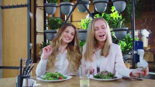 Belles femmes assises à la table avec de savoureuses salades. — Video
