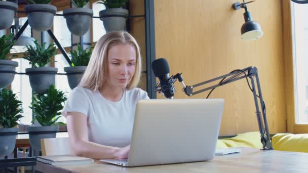 Hezká žena pracující na rádiu s mikrofonem a notebookem. — Stock video