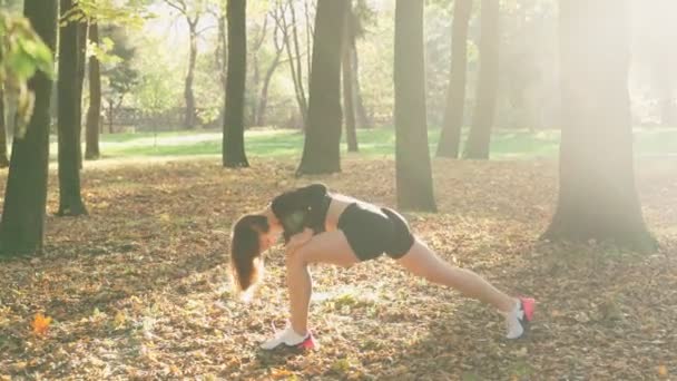 Atleta femminile flettendo le gambe mentre si allena al parco — Video Stock