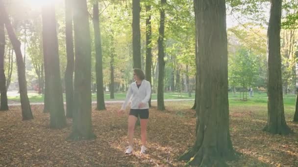 Vrouwelijke loper stretching lichaam in het stadspark — Stockvideo