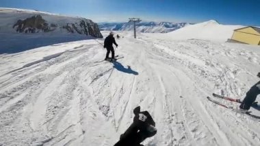 Kayakçı elinde kamerayla yokuş aşağı gidiyor..