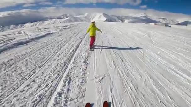 Lyžař po snowboardistovi na sjezdovce. — Stock video