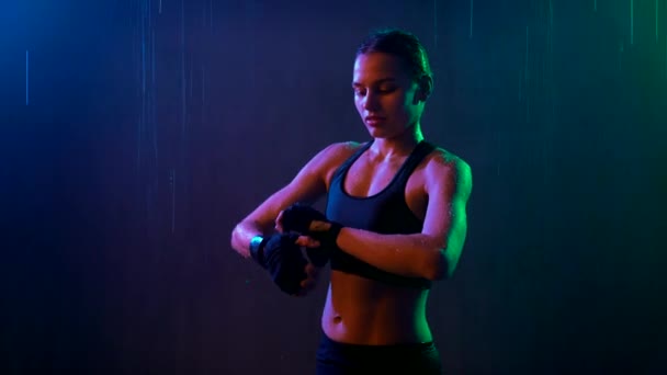Female fighter binding bandage on hand, rain. — Stock video