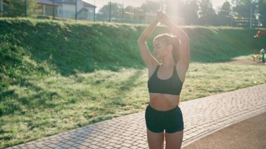 Stadyumda genç, sıska bir kadın ısınıyor..