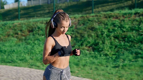 Kobiecy trening biegaczy na stadionie, noszenie słuchawek. — Zdjęcie stockowe