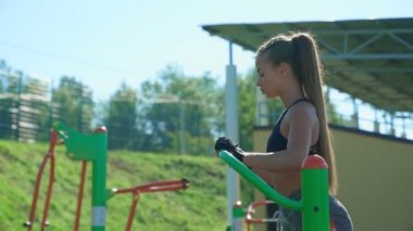 Dışarıdaki spor sahasında simülatör kullanan kadın.