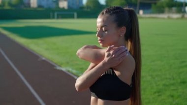 Genç bir kadın stadyumda ısınıyor..