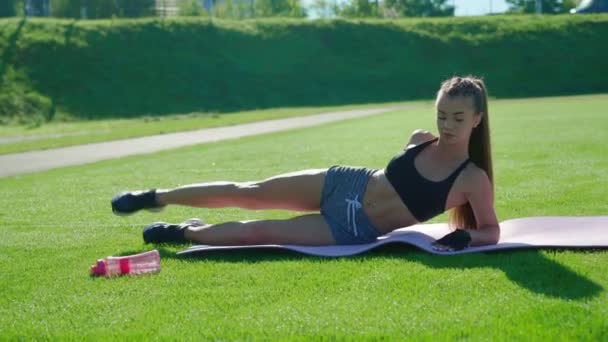 Vrouw verhogen been omhoog op gras. — Stockvideo