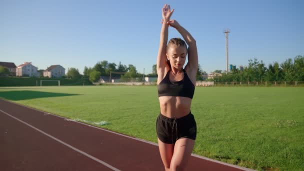 Meisje oefenen full body warming-up oefeningen in het stadion. — Stockvideo