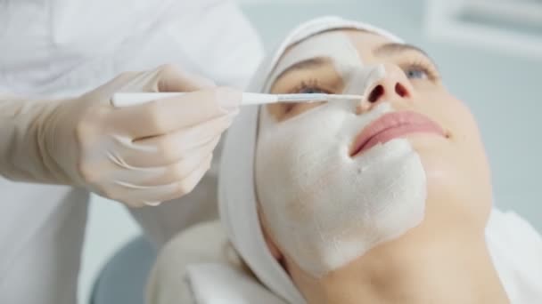 Jovem mulher gostando de aplicar máscara cosmética para rosto. — Vídeo de Stock