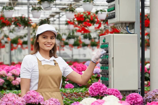 Smiling woman working in greenhouse with technology. — Stock Photo, Image
