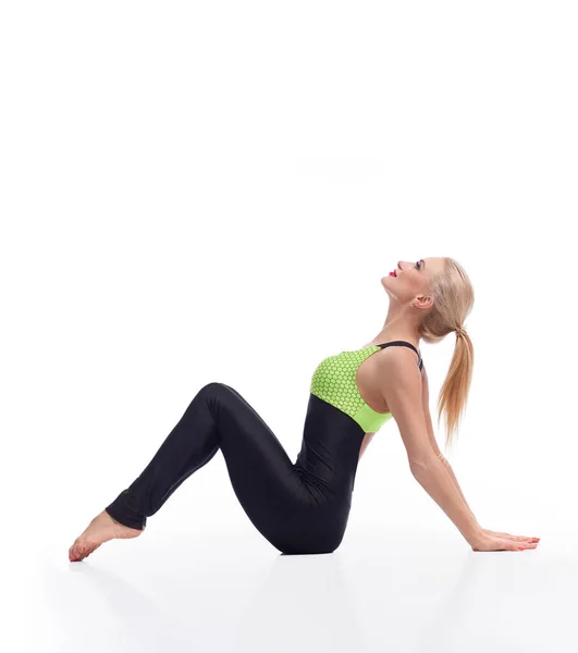 Underbar ung kvinna som utövar yoga sittande på golvet — Stockfoto