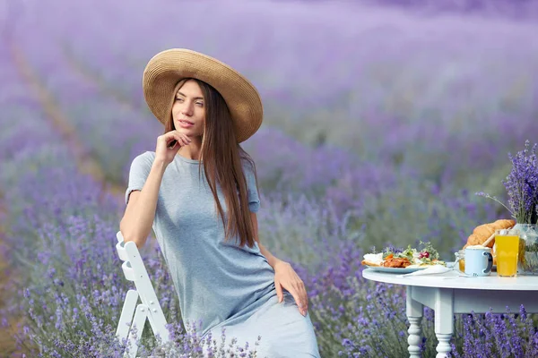 Hymyilevä nuori upea nainen poseeraa laventelipellolla. — kuvapankkivalokuva