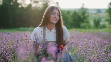 Gülen kadın çiçek açan lavanta tarlasında poz veriyor..