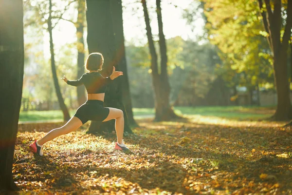 Fitness kobieta rozciągająca nogi w słoneczny dzień w parku — Zdjęcie stockowe