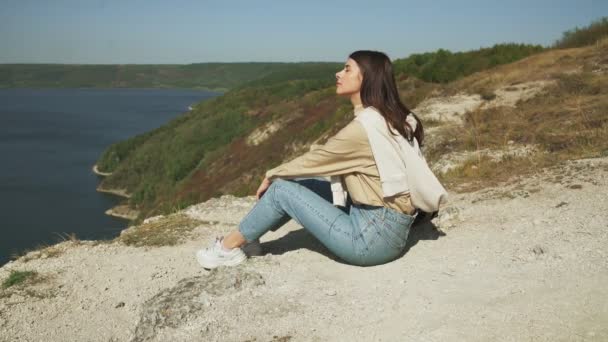 Agréable femme assise sur une colline près de la rivière Dniester — Video