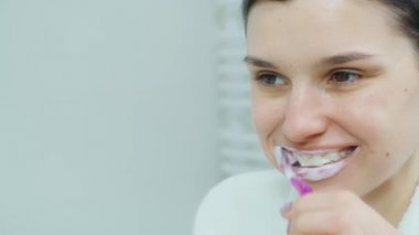 Diş fırçasıyla diş temizleyen güzel bir kadın.