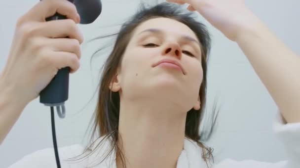 Nő fehér fürdőköpenyben hajszárítás zuhany után — Stock videók