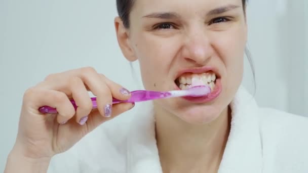 Uśmiechnięta kobieta myje zęby przed lustrem. — Wideo stockowe