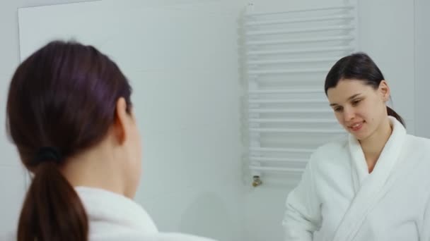 Giovane donna che si ammira nello specchio in bagno. — Video Stock