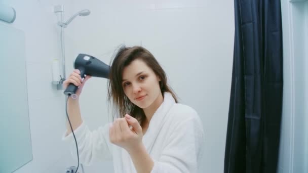 Beautiful woman in white bathrobe drying hair at bathroom. — Stock Video