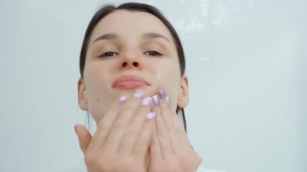 Bella donna massaggiare la pelle per mantenere il viso in buone condizioni. — Video Stock