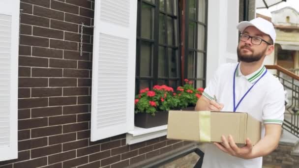 Male courier with badge delivering parcel. — Stock Video