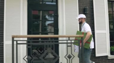 Postacı hediye kutusu ve klasör taşıyor..