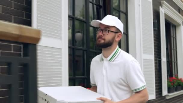 Mensajero alegre llevando cajas de pizza. — Vídeo de stock